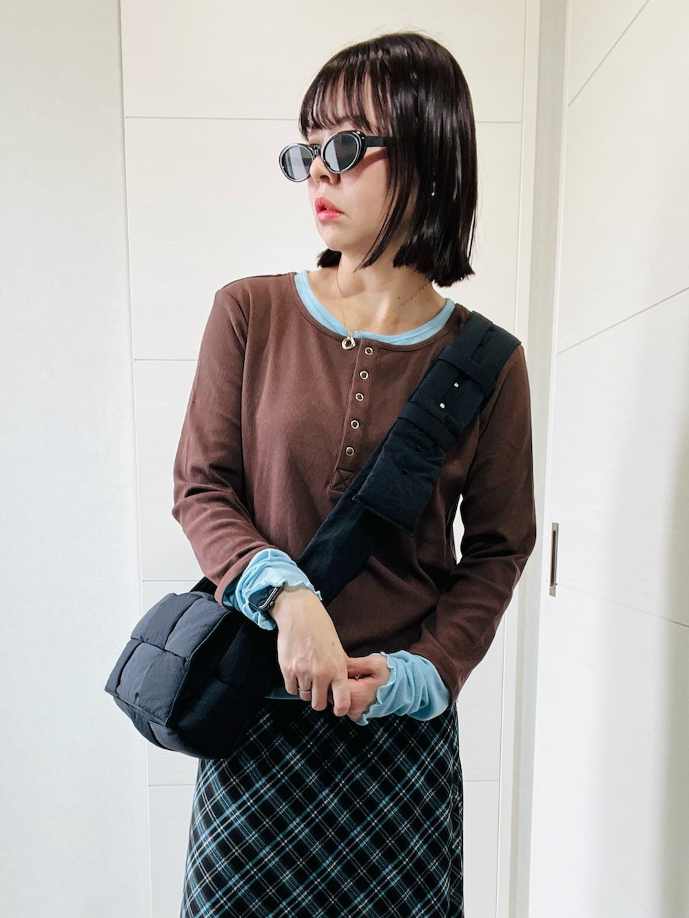 ブラウン系のTシャツ/カットソー、ブラウン系のスカート、ブラック系のローファーを着用したレディースの秋コーディネートの2枚目の写真