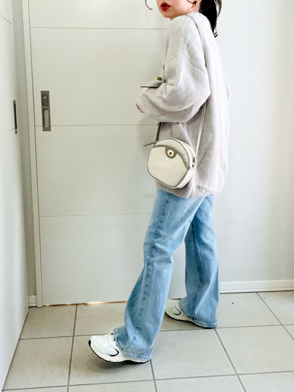 ホワイト系のTシャツ/カットソー、グレー系のカーディガン/ボレロ、ブルー系のデニムパンツを着用したレディースの冬コーディネートの4枚目の写真