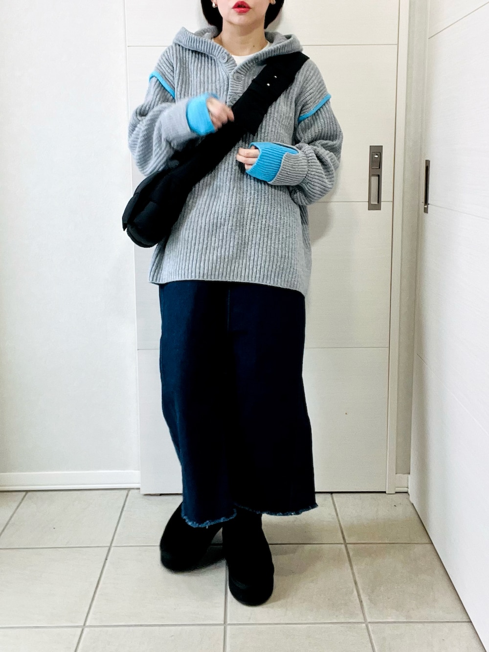 グレー系のニット/セーター、ブルー系のスカート、ブラック系のブーツを着用したレディースの冬コーディネートの4枚目の写真