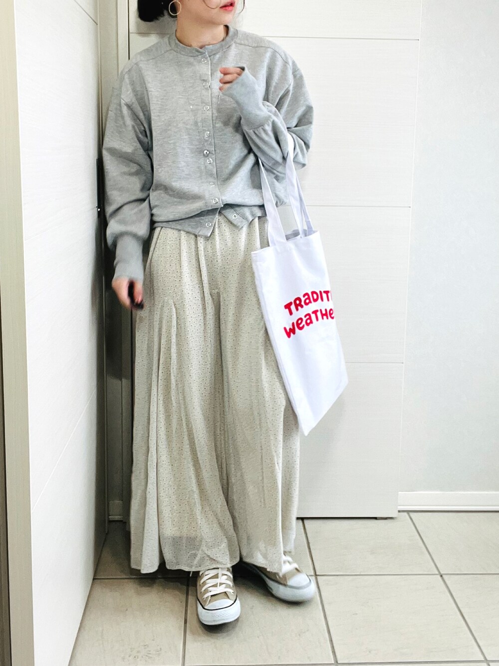 グレー系のカーディガン/ボレロ、グリーン系のスカート、ベージュ系のスニーカーを着用したレディースの春コーディネートの4枚目の写真