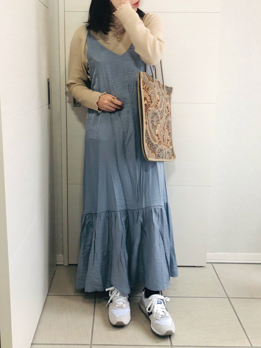 ブルー系のワンピース、ベージュ系のTシャツ/カットソー、ホワイト系のスニーカーを着用したレディースの秋コーディネートの3枚目の写真