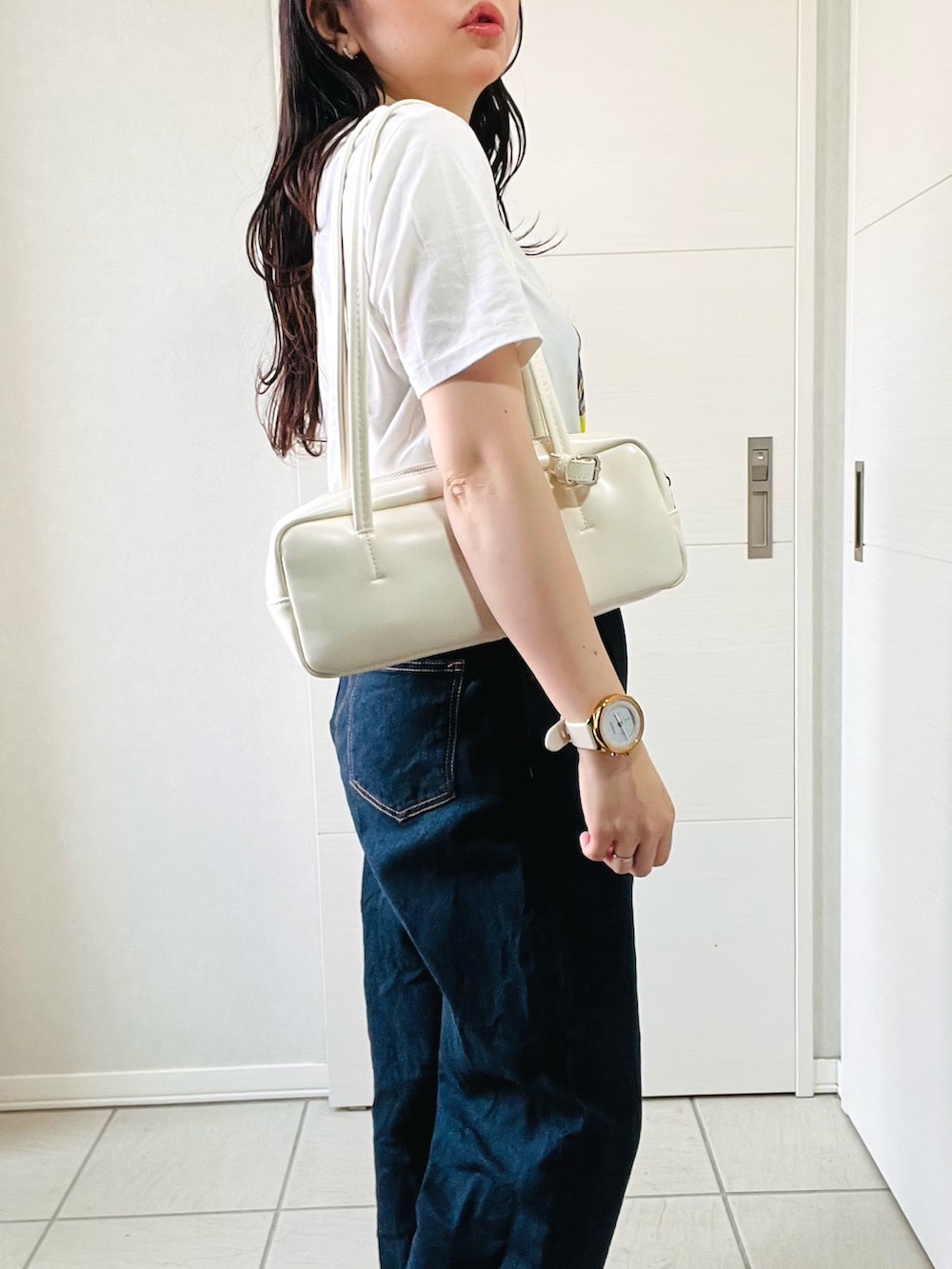 ホワイト系のTシャツ/カットソー、ブルー系のデニムパンツ、ブラック系のスニーカーを着用したレディースの夏コーディネートの3枚目の写真