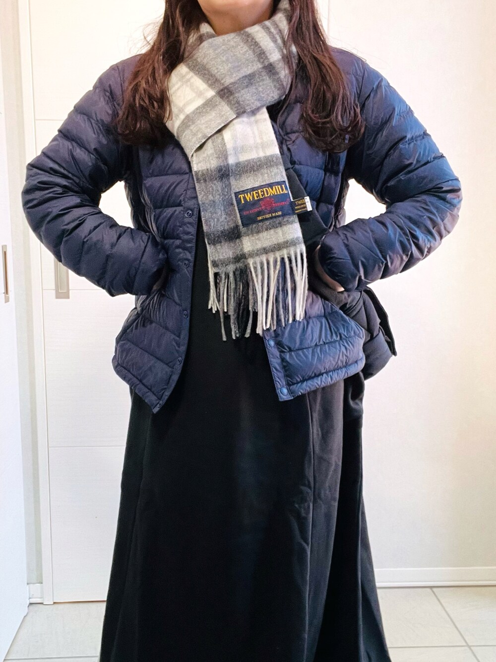 ブルー系のダウンジャケット/コート、ブラック系のワンピース、ベージュ系のスリッポンを着用したレディースの冬コーディネートの2枚目の写真