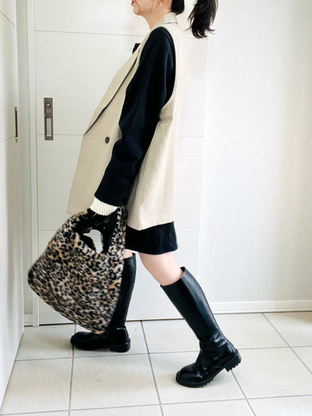 その他のベスト、ブラック系のワンピース、ブラック系のブーツを着用したレディースの秋コーディネートの5枚目の写真