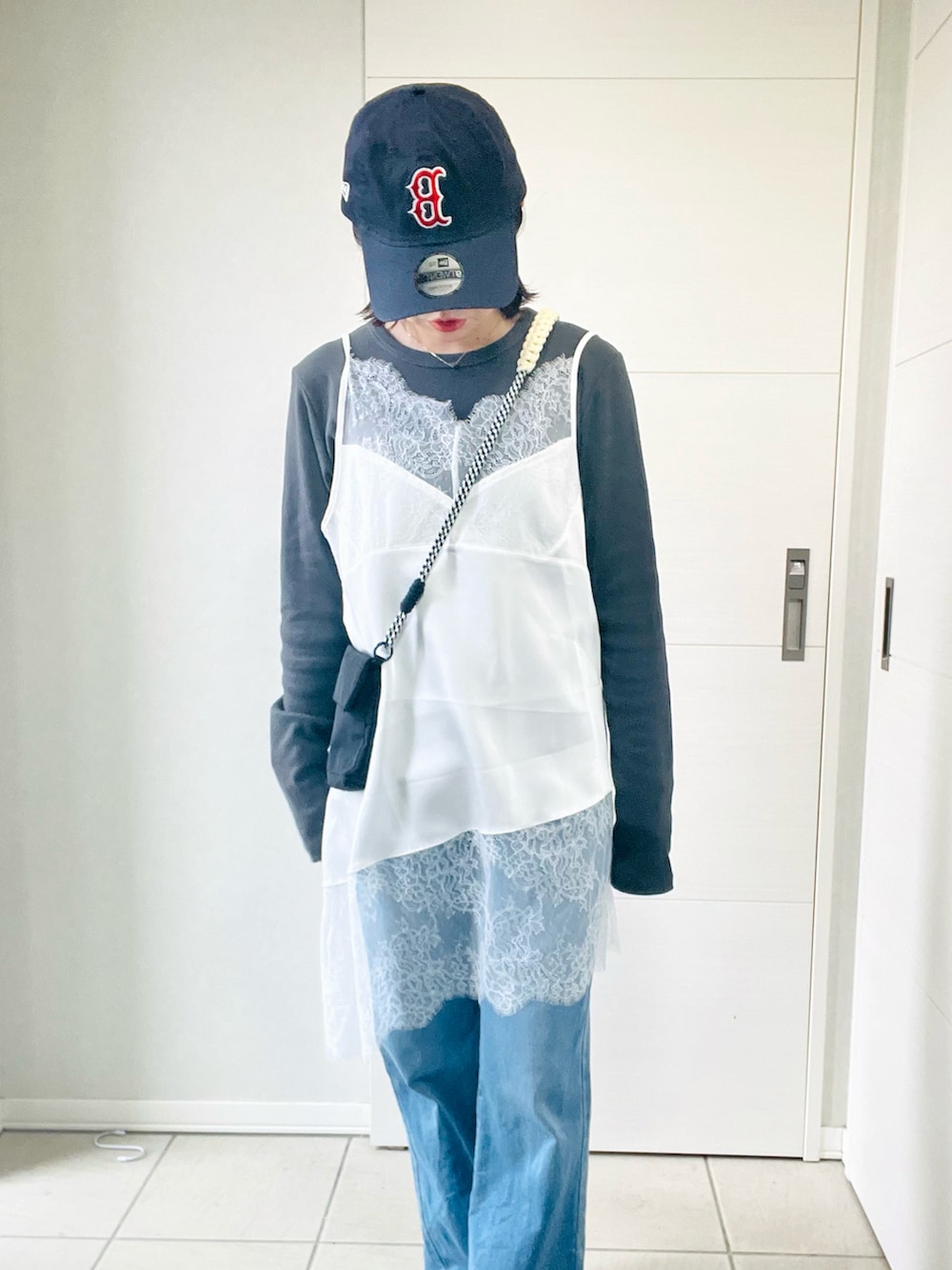 ホワイト系のキャミソール、グレー系のTシャツ/カットソー、ブルー系のデニムパンツを着用したレディースの春コーディネートの2枚目の写真