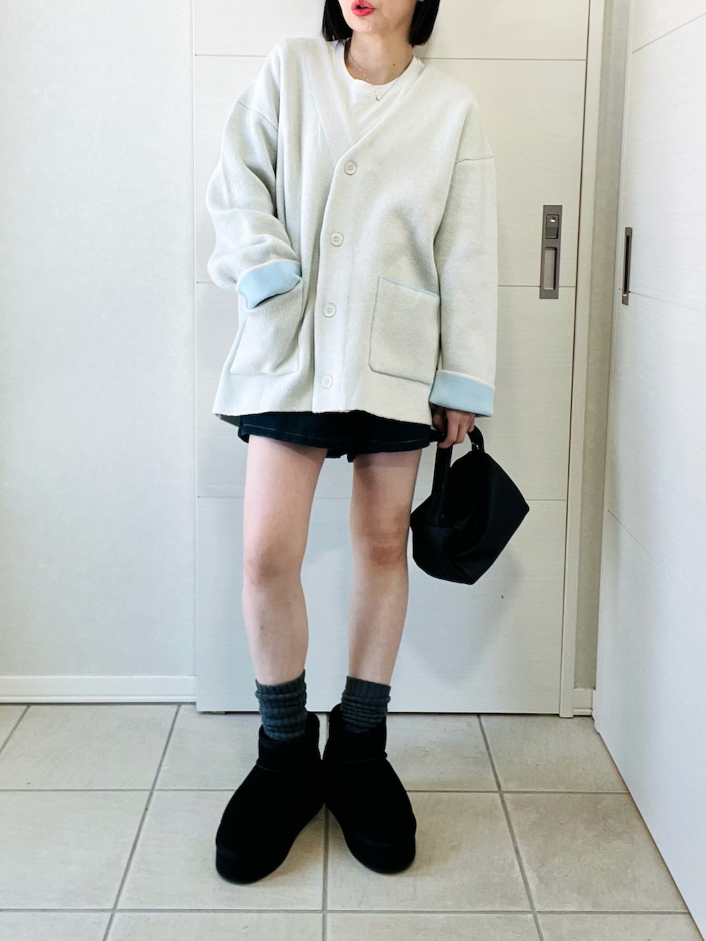 ホワイト系のカーディガン/ボレロ、ブラック系のブーツ、ブラック系のその他パンツを着用したレディースの冬コーディネートの5枚目の写真