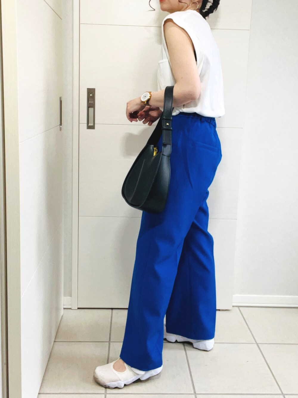 ホワイト系のTシャツ/カットソー、ブルー系のスラックス、ホワイト系のサンダルを着用したレディースの夏コーディネートの5枚目の写真