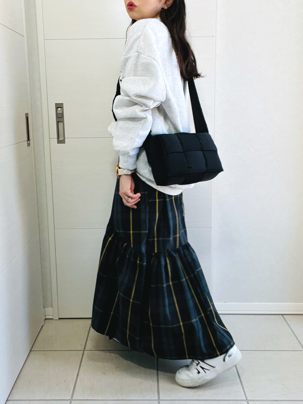 グレー系のスウェット、ブラック系のスカート、ホワイト系のスニーカーを着用したレディースの秋コーディネートの5枚目の写真