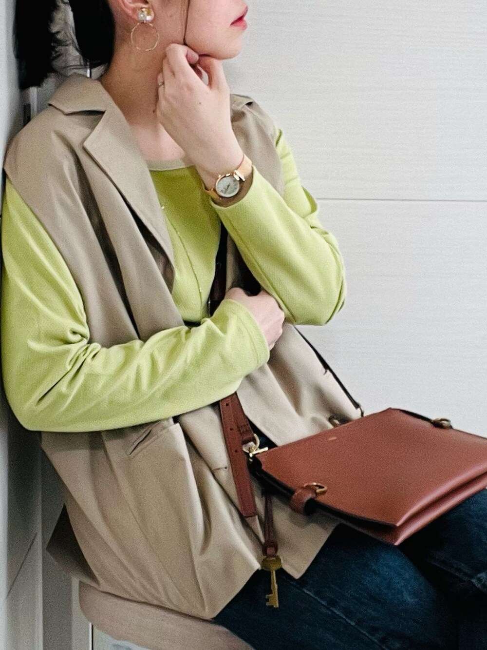 ブラウン系のメッセンジャーバッグ、グリーン系のTシャツ/カットソー、ベージュ系のテーラードジャケットを着用したレディースの春コーディネートの3枚目の写真
