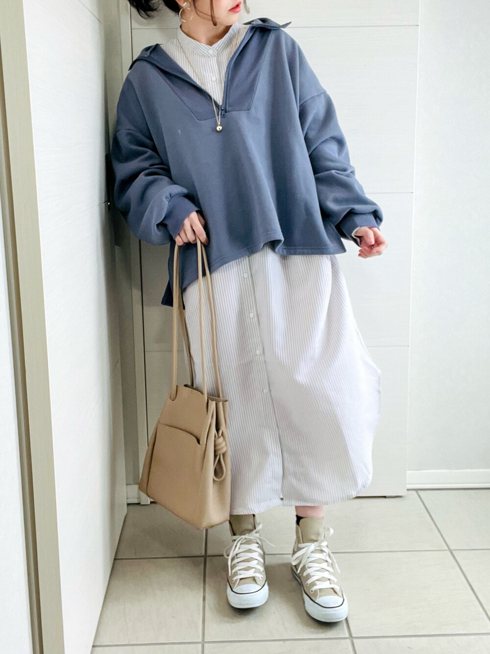 ブルー系のスウェット、ベージュ系のシャツワンピース、ベージュ系のスニーカーを着用したレディースの冬コーディネートの3枚目の写真