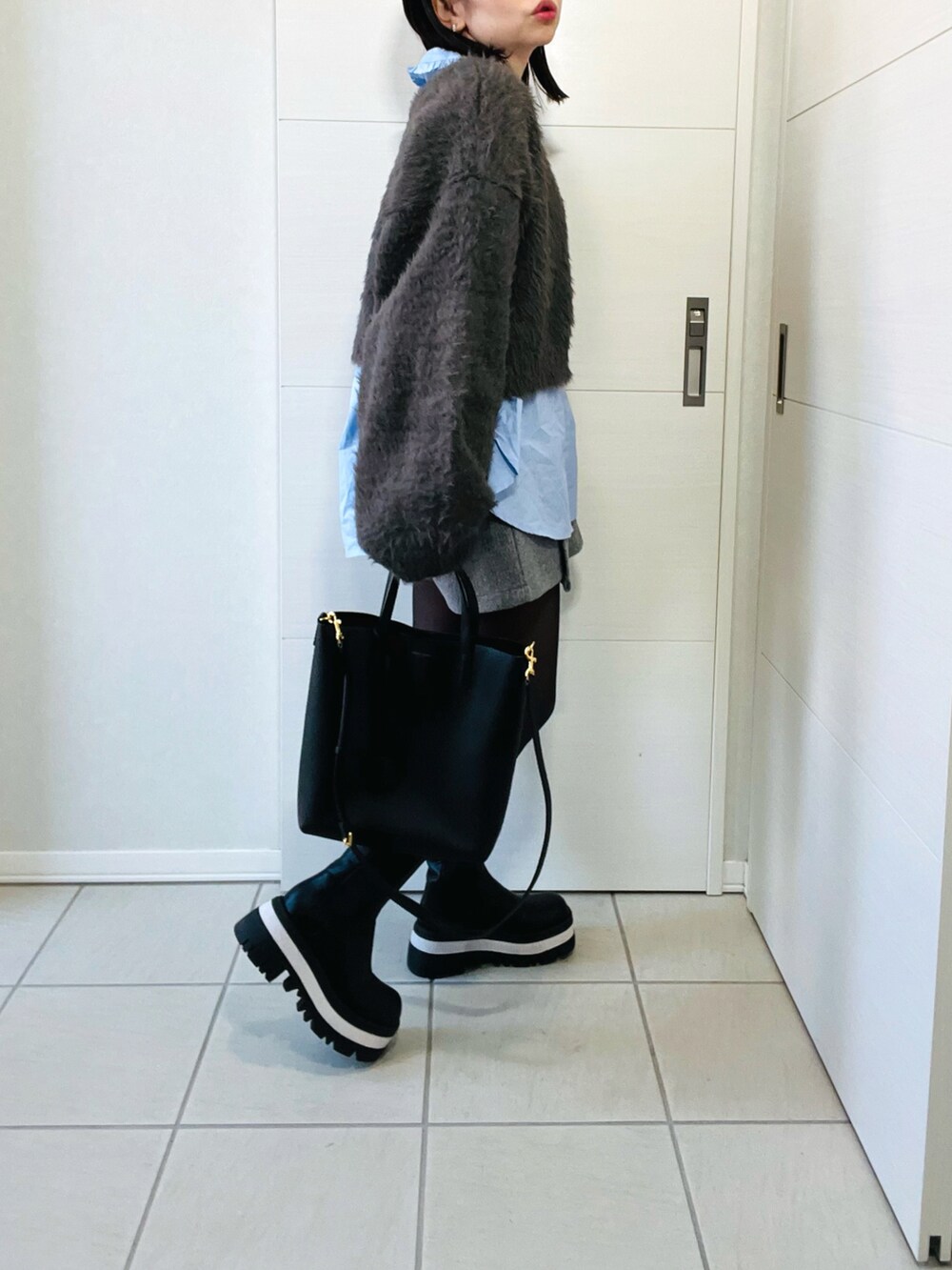 グレー系のニット/セーター、ブルー系のシャツ/ブラウス、グレー系のその他パンツを着用したレディースの冬コーディネートの5枚目の写真