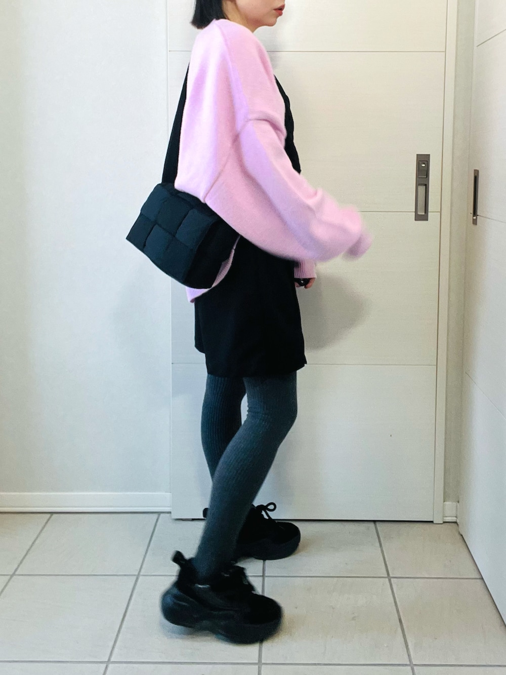 ピンク系のニット/セーター、ブラック系のその他パンツ、ブラック系のスニーカーを着用したレディースの冬コーディネートの4枚目の写真