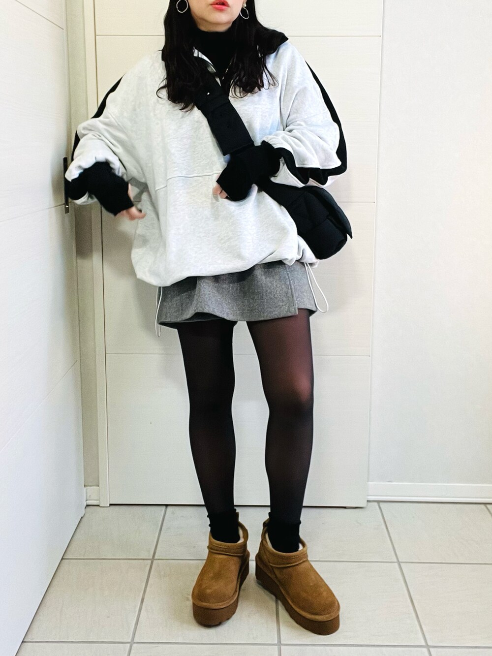 グレー系のスウェット、ブラック系のニット/セーター、グレー系のその他パンツを着用したレディースの冬コーディネートの5枚目の写真