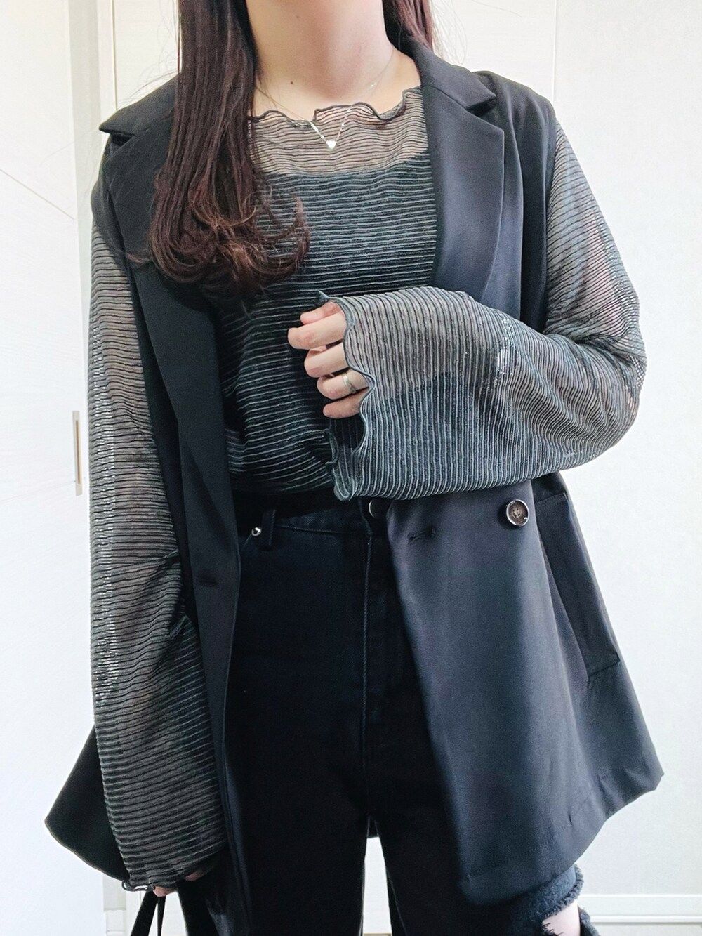 グレー系のTシャツ/カットソー、ブラック系のベスト、ブラック系のデニムパンツを着用したレディースの春コーディネートの2枚目の写真