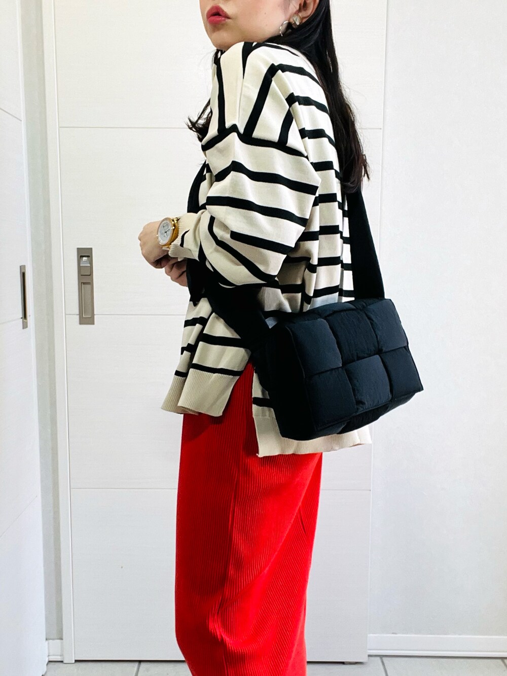 ホワイト系のニット/セーター、オレンジ系のスカート、ブラック系のローファーを着用したレディースの秋コーディネートの3枚目の写真