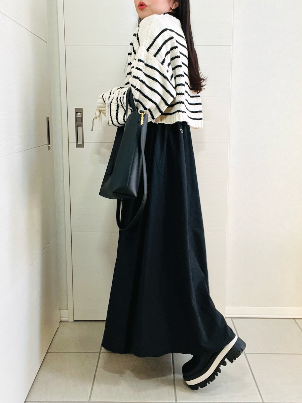 その他のニット/セーター、グリーン系のワンピース、ブラック系のブーツを着用したレディースの冬コーディネートの5枚目の写真