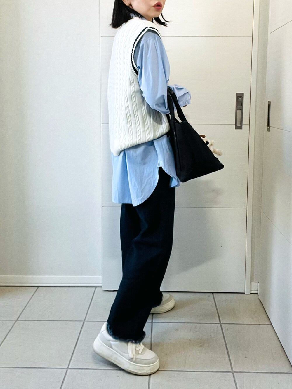ホワイト系のベスト、ブルー系のシャツ/ブラウス、ブルー系のデニムパンツを着用したレディースの春コーディネートの5枚目の写真