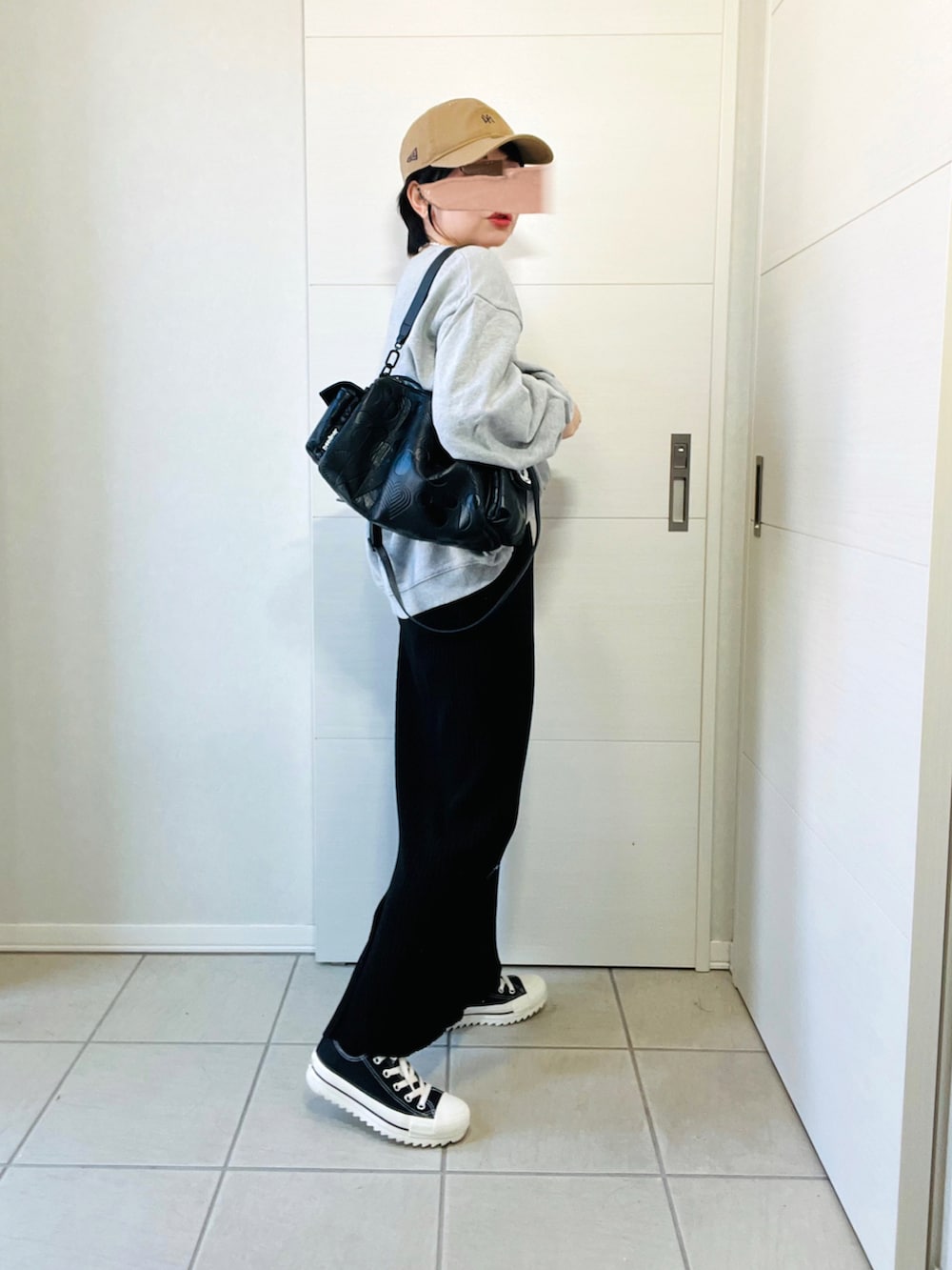 グレー系のスウェット、ブラック系のスカート、ブラック系のスニーカーを着用したレディースの秋コーディネートの5枚目の写真