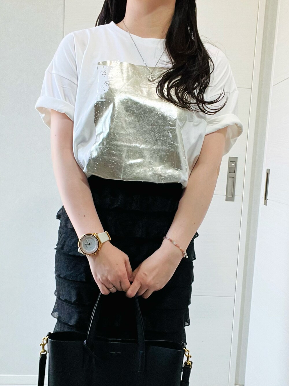 ホワイト系のTシャツ/カットソー、ブラック系のスカート、ブラック系のサンダルを着用したレディースの夏コーディネートの2枚目の写真