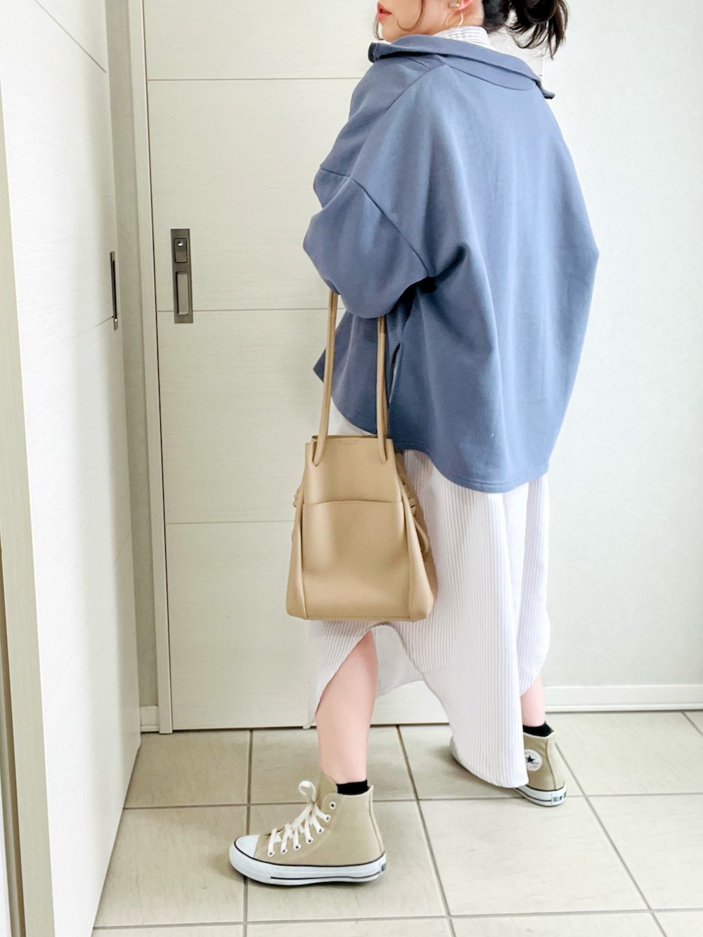 ブルー系のスウェット、ベージュ系のシャツワンピース、ベージュ系のスニーカーを着用したレディースの冬コーディネートの2枚目の写真