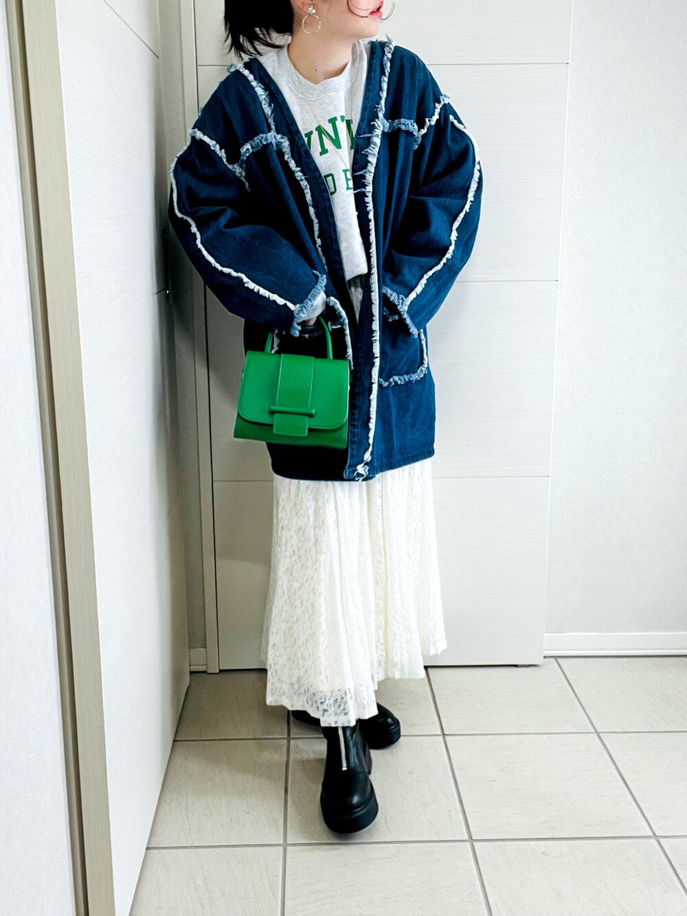 ブルー系のデニムジャケット、グレー系のスウェット、ホワイト系のスカートを着用したレディースの冬コーディネートの2枚目の写真