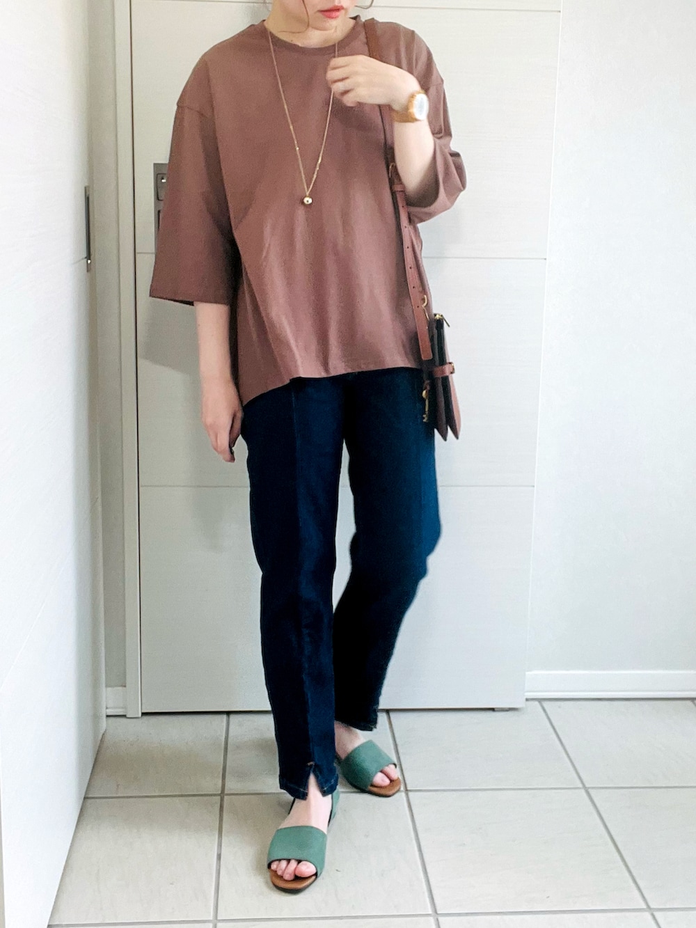 ブラウン系のTシャツ/カットソー、ブルー系のデニムパンツ、グリーン系のサンダルを着用したレディースの夏コーディネートの3枚目の写真