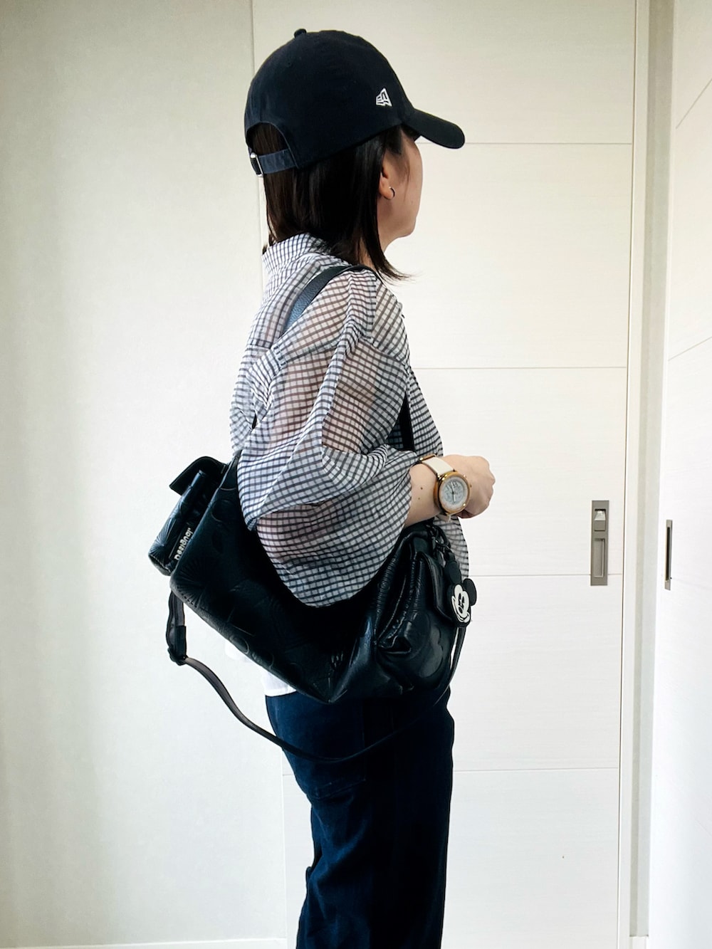 ホワイト系のシャツ/ブラウス、グレー系のスニーカー、ブラック系のハンドバッグを着用したレディースの夏コーディネートの3枚目の写真