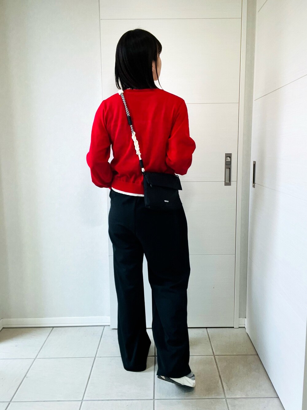 レッド系のカーディガン/ボレロ、ブラック系のその他パンツ、グレー系のスニーカーを着用したレディースの春コーディネートの4枚目の写真