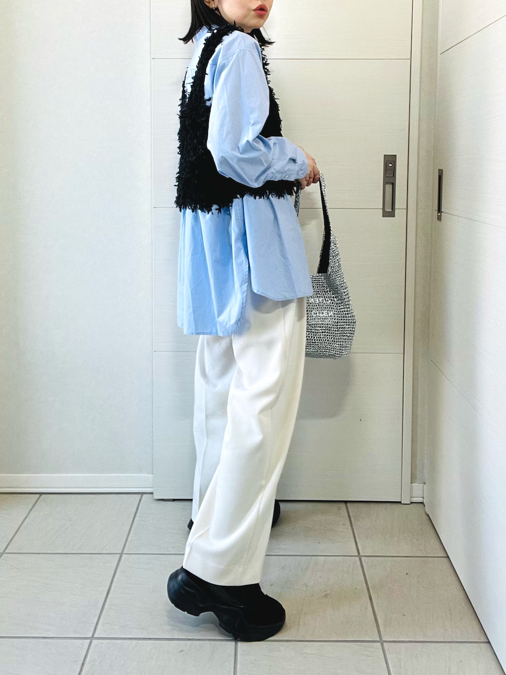 ブラック系のベスト、ブルー系のシャツ/ブラウス、ホワイト系のスラックスを着用したレディースの春コーディネートの5枚目の写真