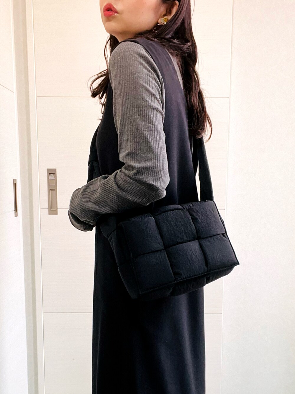 グレー系のTシャツ/カットソー、ブラック系のスカート、ホワイト系のスニーカーを着用したレディースの秋コーディネートの3枚目の写真