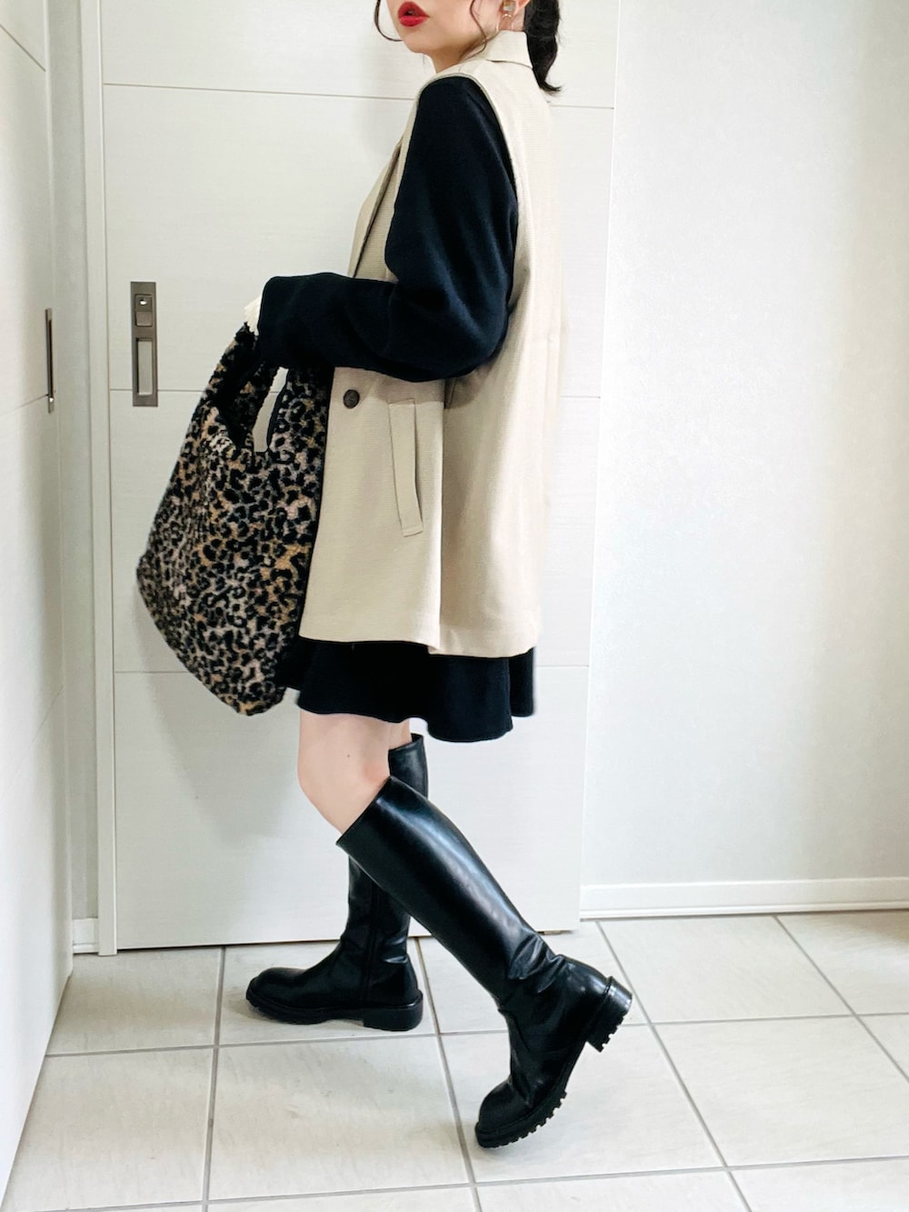 その他のベスト、ブラック系のワンピース、ブラック系のブーツを着用したレディースの秋コーディネートの4枚目の写真