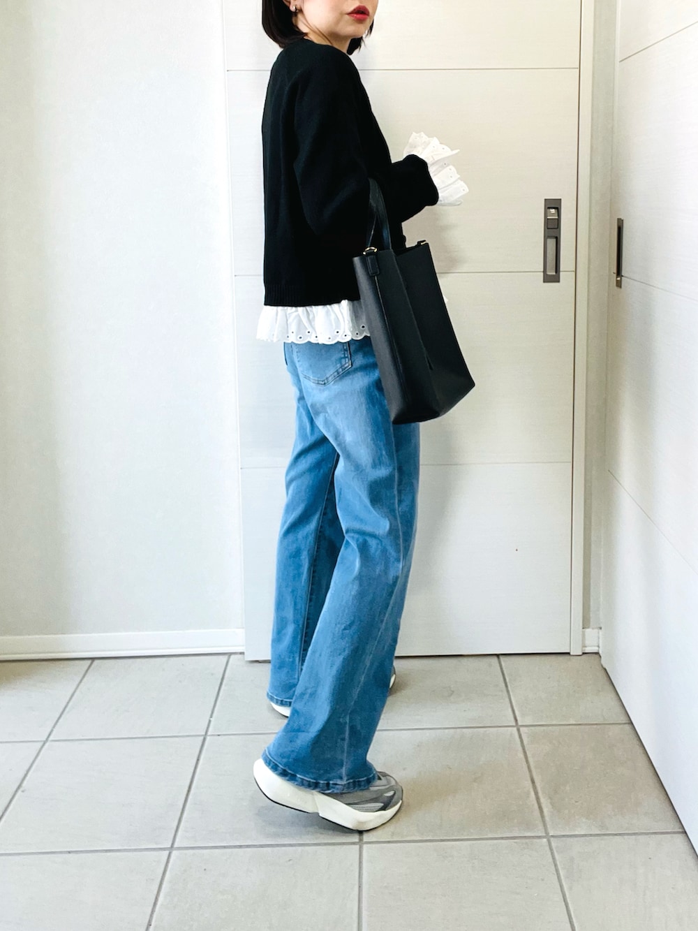 グレー系のスニーカー、ブルー系のデニムパンツ、ブラック系のカーディガン/ボレロを着用したレディースの春コーディネートの5枚目の写真