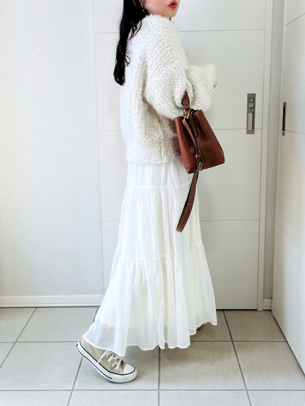 ブラウン系のショルダーバッグ、ベージュ系のニット/セーター、ホワイト系のスカートを着用したレディースの秋コーディネートの5枚目の写真