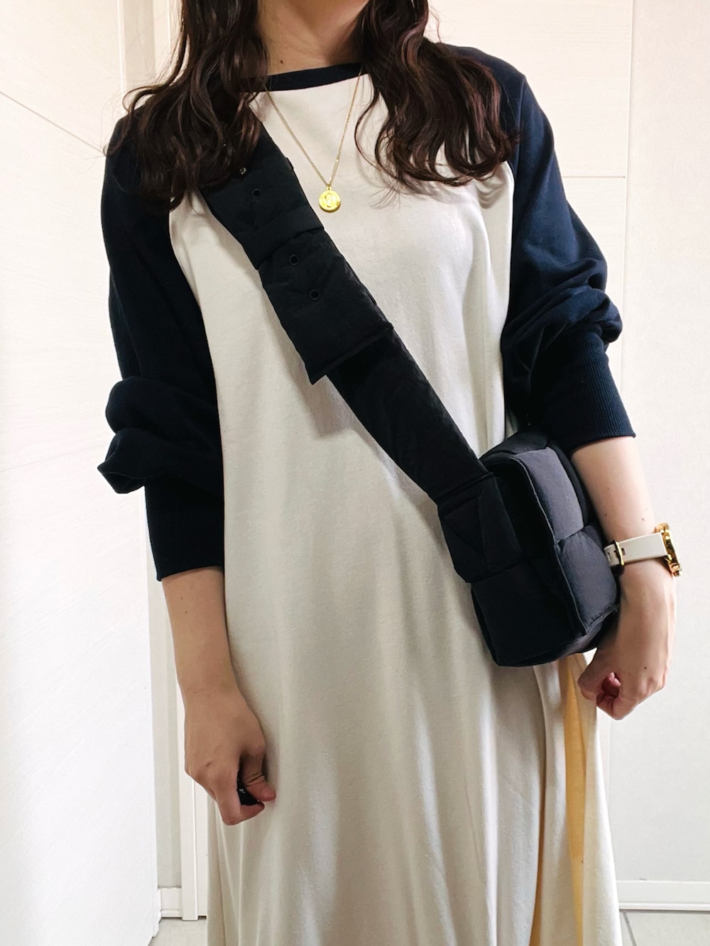 ホワイト系のワンピース、ホワイト系のスニーカー、ブラック系のショルダーバッグを着用したレディースの秋コーディネートの2枚目の写真