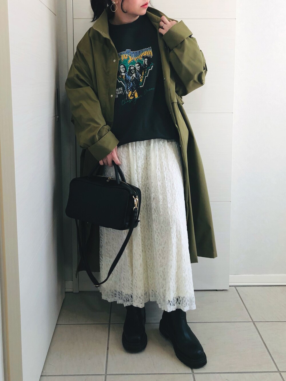 グリーン系のモッズコート、ブラック系のスウェット、ホワイト系のスカートを着用したレディースの冬コーディネートの2枚目の写真