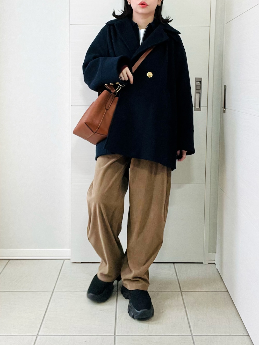 ブルー系のニット/セーター、ベージュ系のその他パンツ、ブラック系のブーツを着用したレディースの冬コーディネートの5枚目の写真