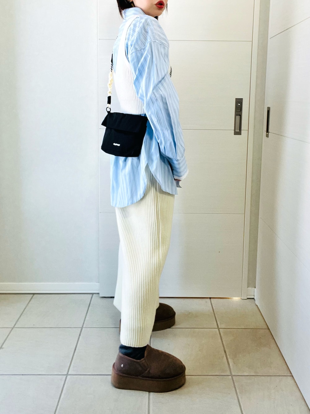 ブルー系のシャツ/ブラウス、ホワイト系のスカート、ブラック系のショルダーバッグを着用したレディースの冬コーディネートの5枚目の写真