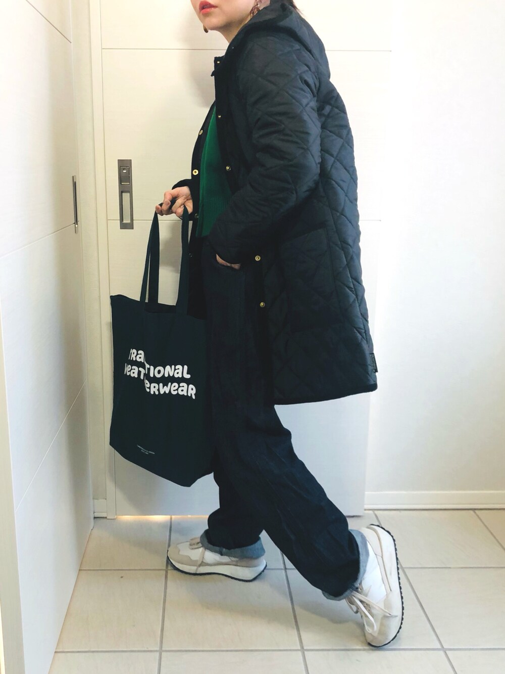 ブラック系のノーカラーコート、グリーン系のカーディガン/ボレロ、ブルー系のセットアップを着用したレディースの冬コーディネートの2枚目の写真