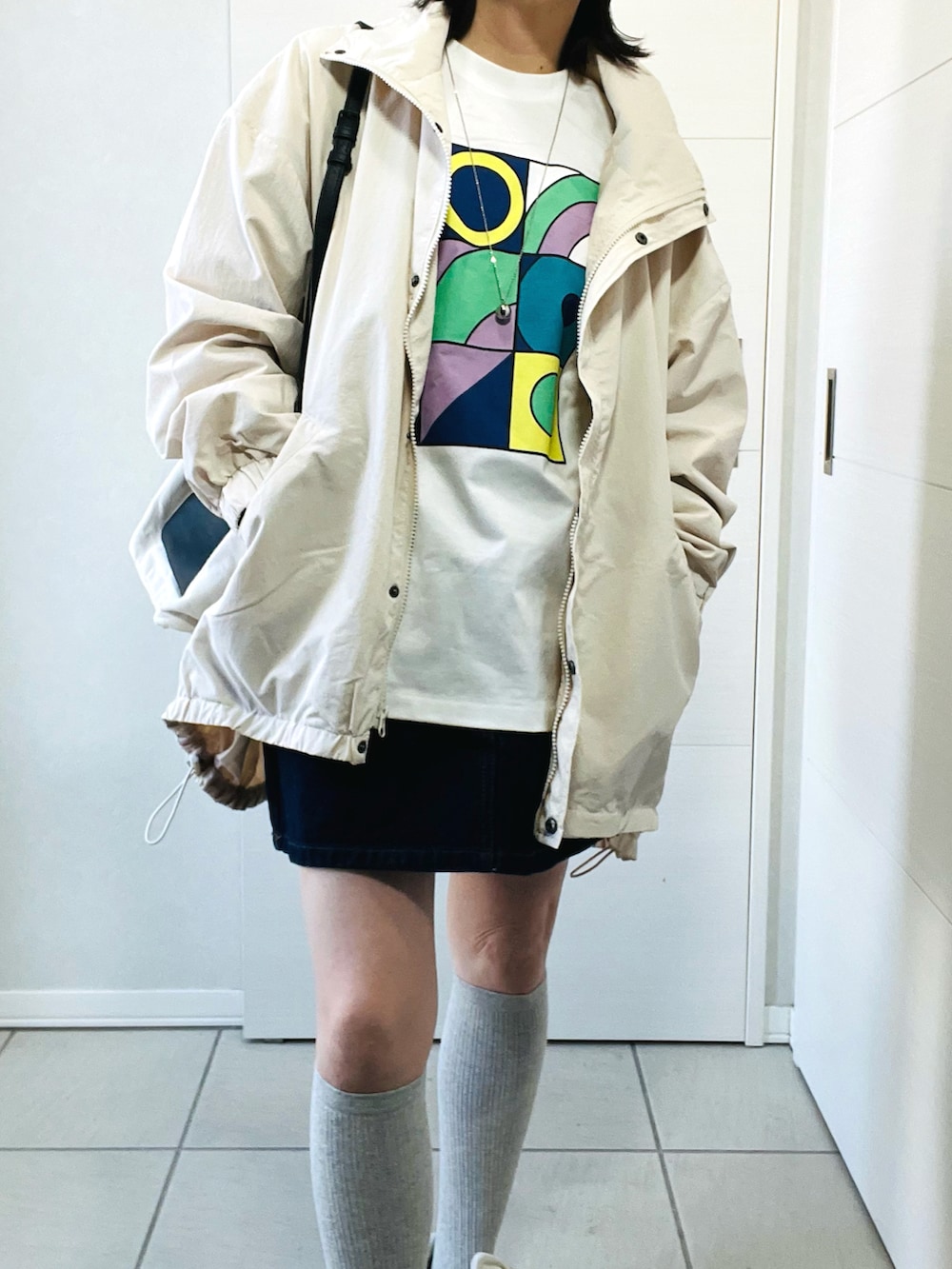 ホワイト系のナイロンジャケット、その他のTシャツ/カットソー、ブルー系のデニムスカートを着用したレディースの春コーディネートの2枚目の写真