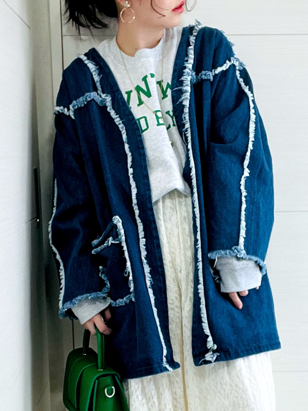 ブルー系のデニムジャケット、グレー系のスウェット、ホワイト系のスカートを着用したレディースの冬コーディネートの4枚目の写真