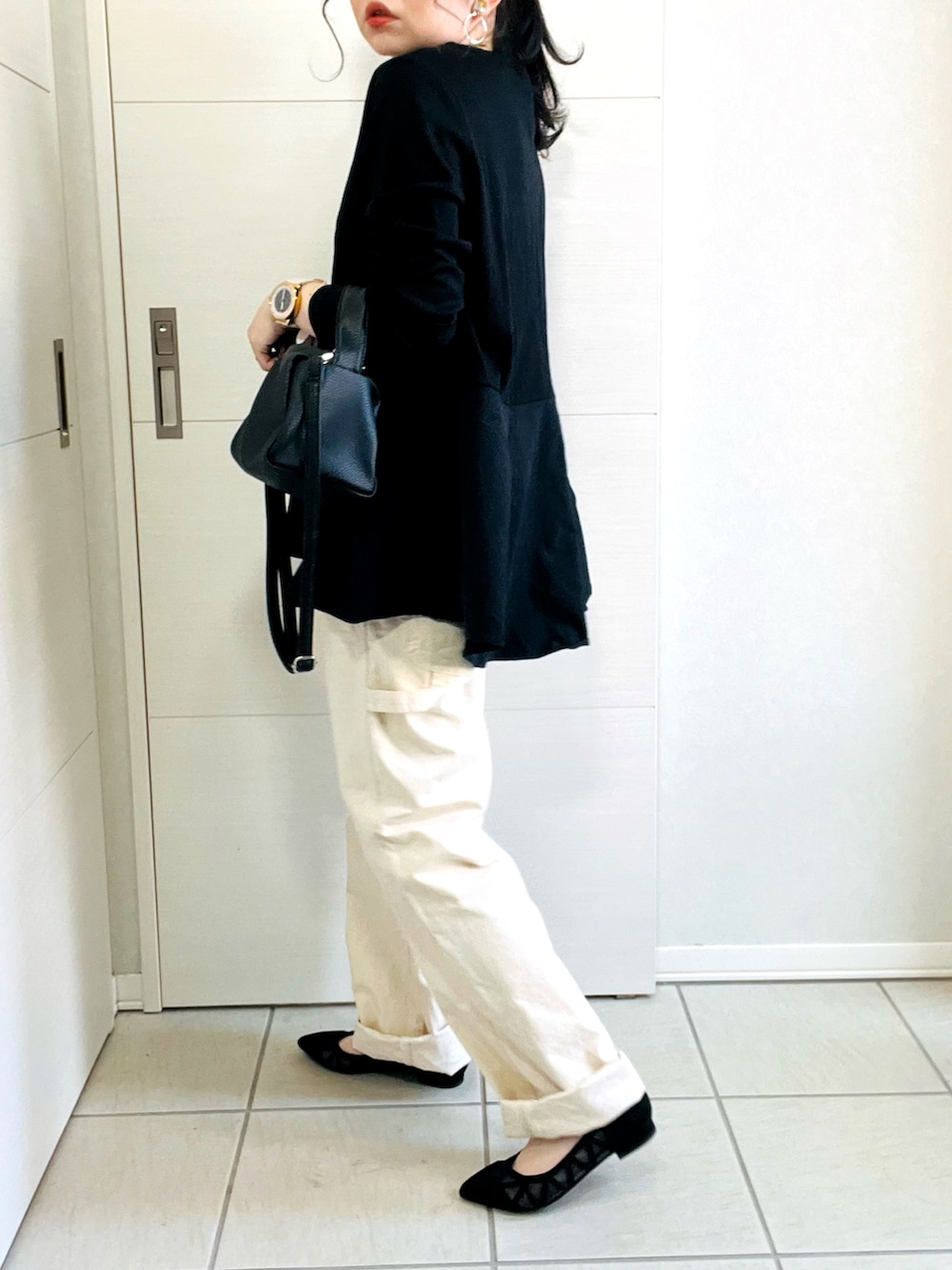 ブラック系のTシャツ/カットソー、ホワイト系のデニムパンツ、ブラック系のパンプスを着用したレディースの春コーディネートの2枚目の写真