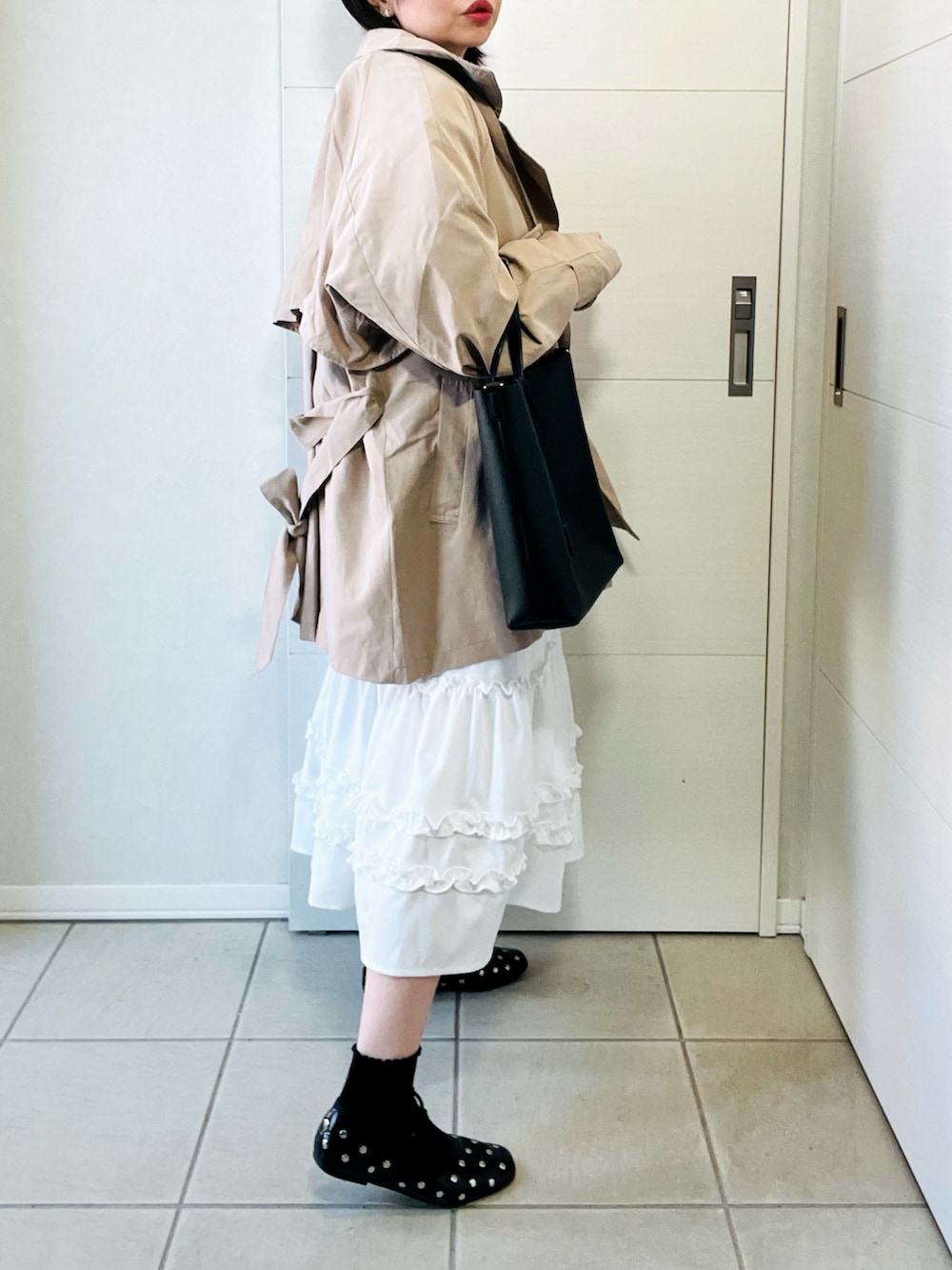 ベージュ系のトレンチコート、ブルー系のシャツ/ブラウス、ホワイト系のスカートを着用したレディースの春コーディネートの5枚目の写真