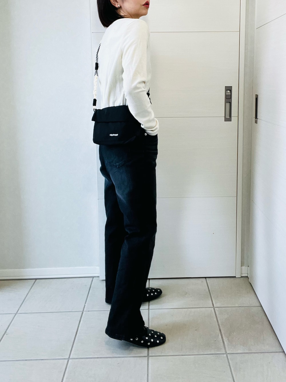 ホワイト系のTシャツ/カットソー、ブラック系のデニムパンツ、ブラック系のショルダーバッグを着用したレディースの春コーディネートの5枚目の写真