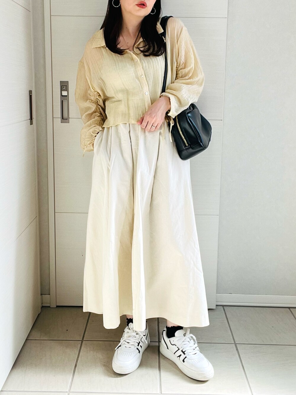 イエロー系のシャツ/ブラウス、ホワイト系のデニムスカート、ホワイト系のスニーカーを着用したレディースの夏コーディネートの5枚目の写真