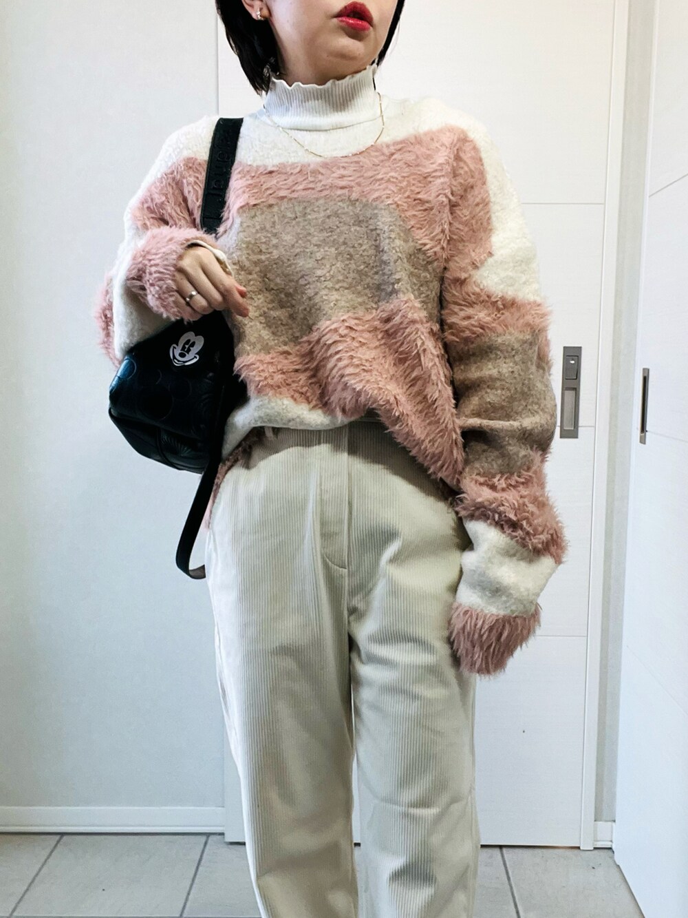 ホワイト系のニット/セーター、ホワイト系のその他パンツ、ブラック系のハンドバッグを着用したレディースの秋コーディネートの2枚目の写真