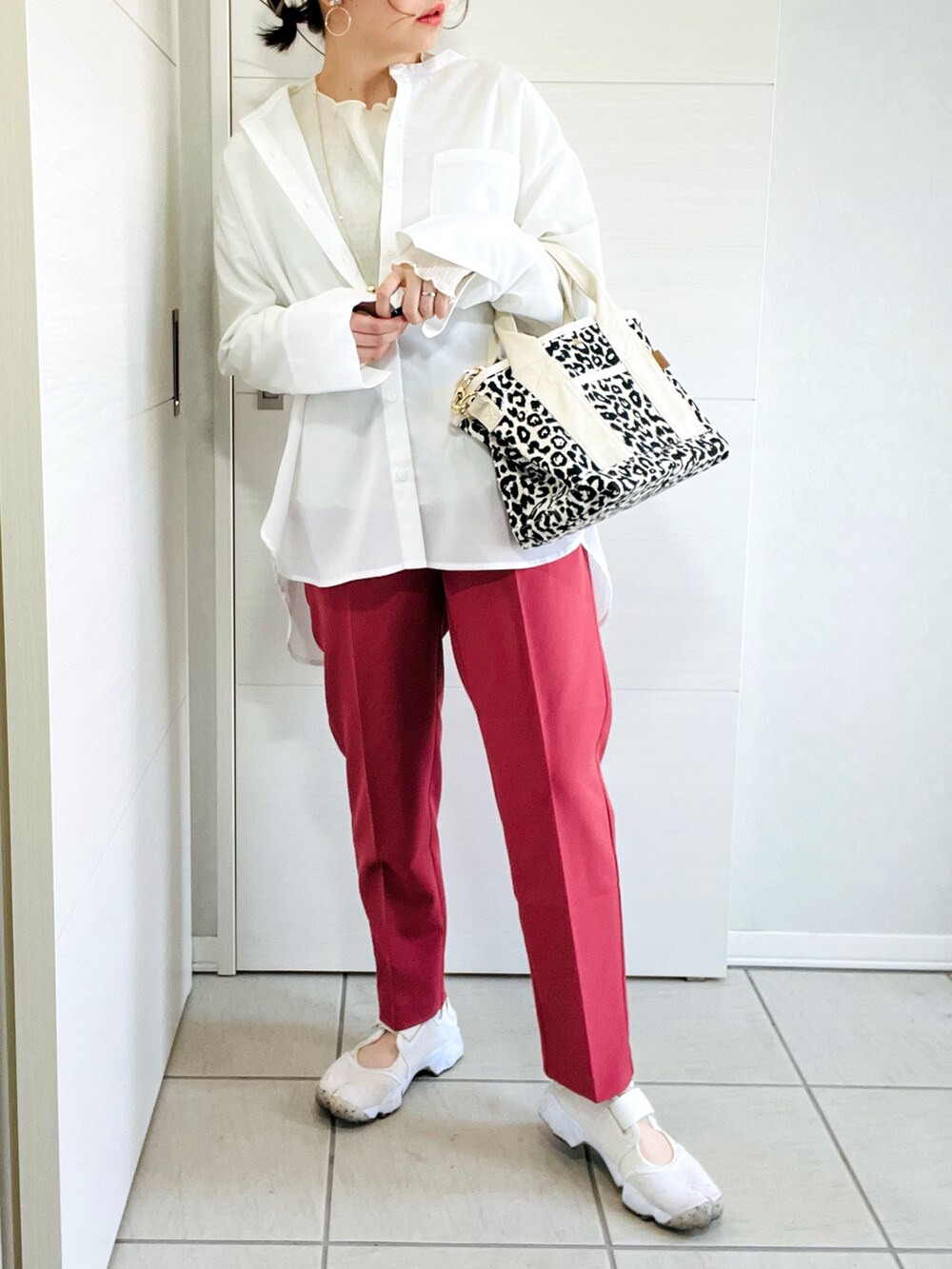 ホワイト系のシャツ/ブラウス、レッド系のスラックス、ホワイト系のスニーカーを着用したレディースの春コーディネートの2枚目の写真
