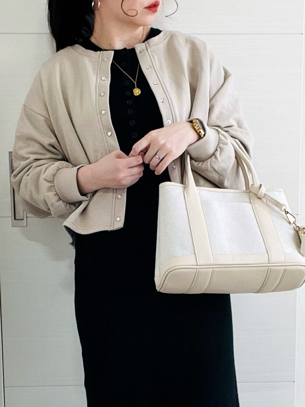 ベージュ系のカーディガン/ボレロ、ブラック系のワンピース、ブラック系のブーツを着用したレディースの冬コーディネートの3枚目の写真