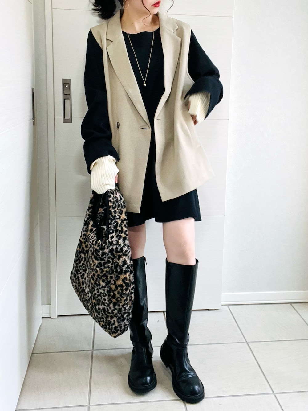 その他のベスト、ブラック系のワンピース、ブラック系のブーツを着用したレディースの秋コーディネートの2枚目の写真