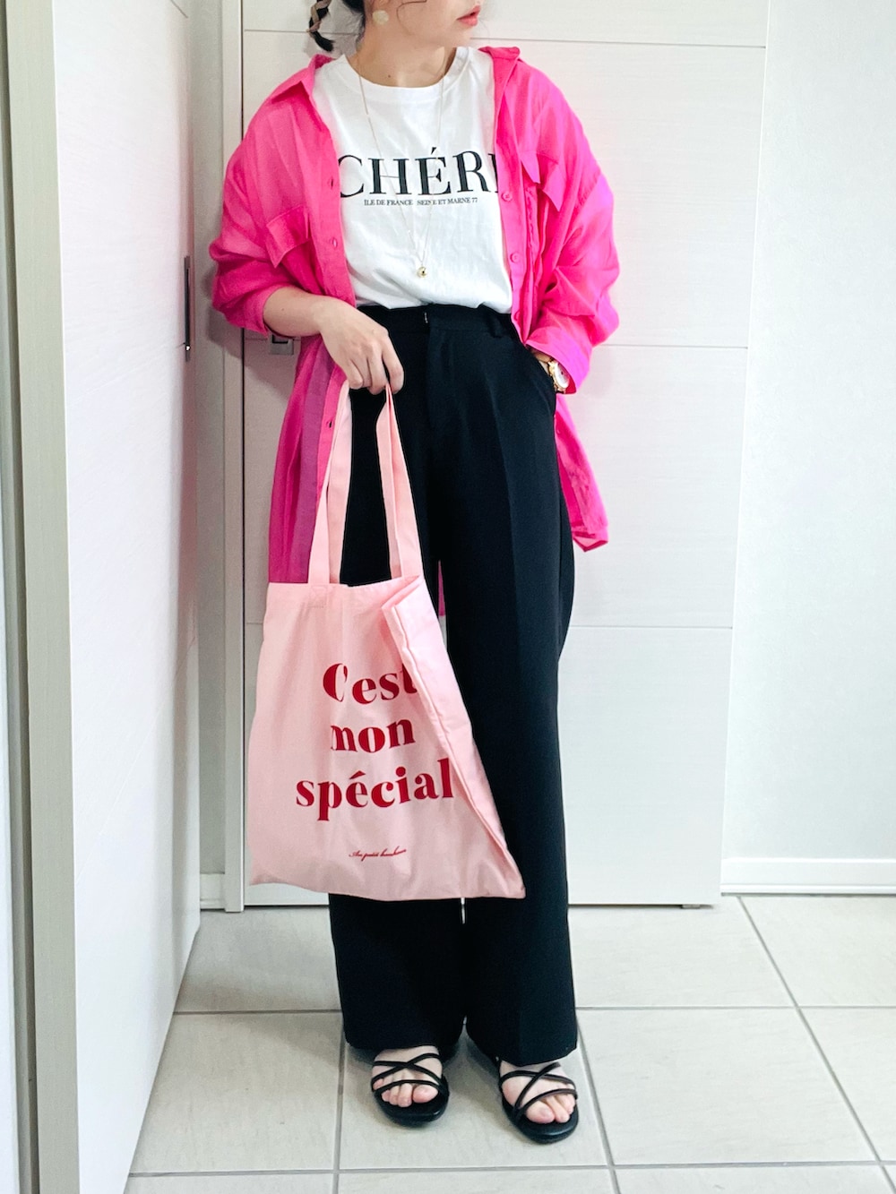 ピンク系のシャツ/ブラウス、ホワイト系のTシャツ/カットソー、ブラック系のスラックスを着用したレディースの夏コーディネートの2枚目の写真