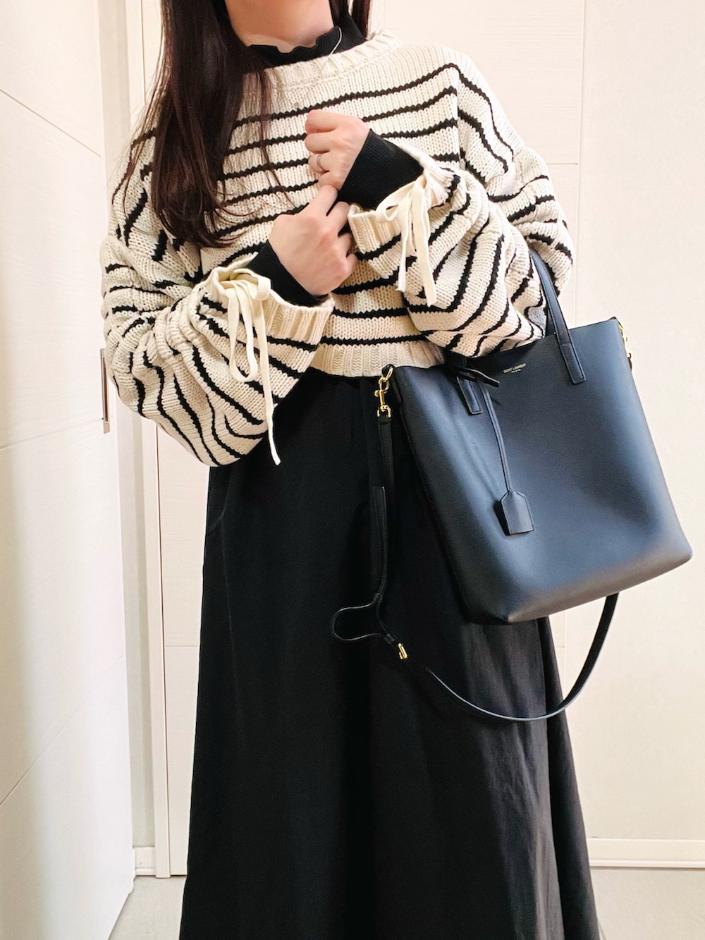 その他のニット/セーター、グリーン系のワンピース、ブラック系のブーツを着用したレディースの冬コーディネートの2枚目の写真